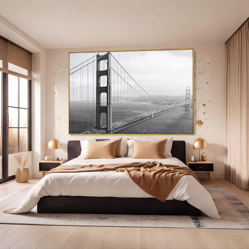 Tablou canvas cu fotografie alb-negru cu podul golden gate, in rama de aluminiu auriu, pe perete intr-un dormitor